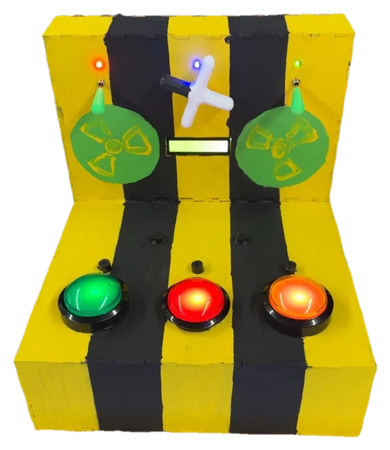 Front view of the reaction game: a yellow and black striped panel with green, red, and orange arcade buttons and two radiation-symbol discs